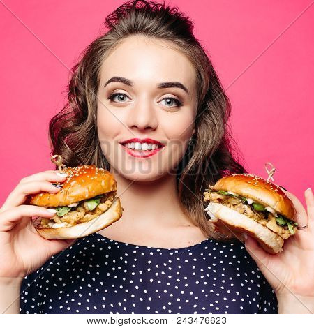 Beautiful Positivity Girl Smilingat Camera And Posing With Two Tasty Humburgers. Young Pretty Woman 