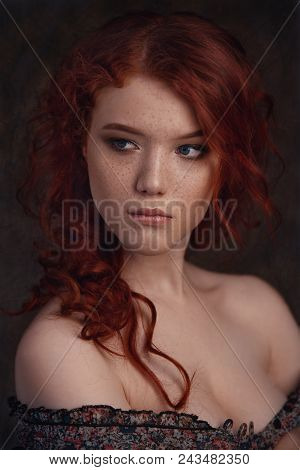 Dramatic Retro Portrait Of A Young Beautiful Dreamy Redhead Woman. Soft Vintage Toning.