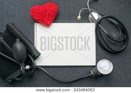 Medical Mockup Flat Lay. White Notebook, Red Thread Heart With Tonometer On Grey Table. Sphygmomanom