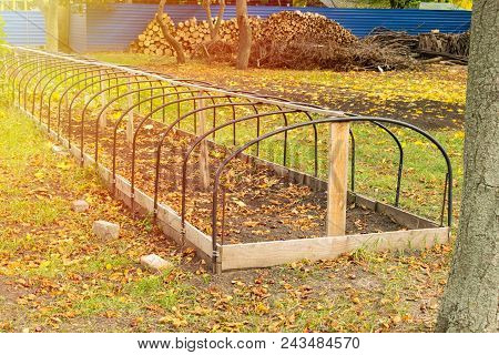 Metal Frame Of Unheated  Greenhouse In An Autumn Park. Preparation Of Greenhouses For Autumn, Winter