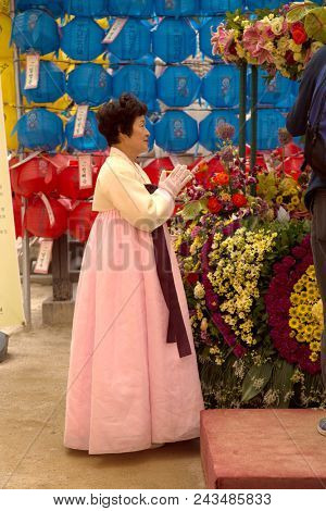 SEOUL-SOUTH KOREA, MAY 20, 2018: Woman with traditional costume at Jogyesa Temple.  It is one of the most important Buddhist temples in Korea with traditional hanji paper lanterns 