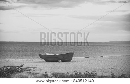 Fishermens Boat At Seacoast, On Sand On Cloudy Day With Sea On Background. Fishing Boat On Beach In 