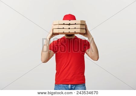 A Deliveryman Hidden Behind A Large Stack Of Pizza Boxes He Is Carrying. Isolated Over Grey Backgrou