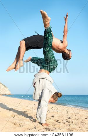 Teen Couple Doing Gimnastics In The Beach