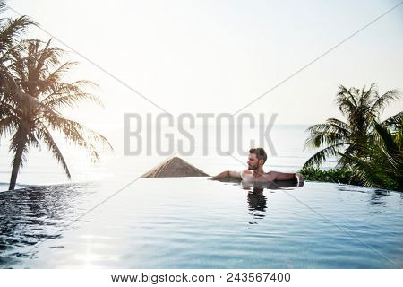 Handsome guy relaxing in swimming pool