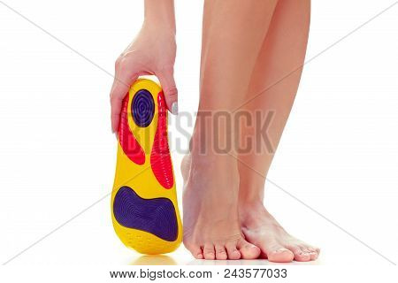 Orthopedic Insole In The Hand And Female Feet Stand On Tiptoe