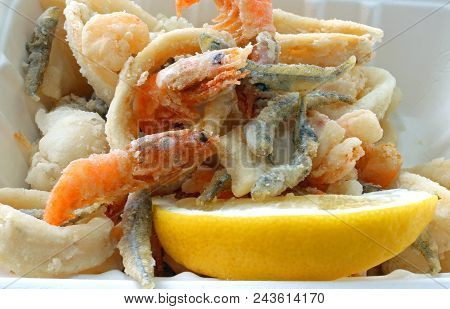 Appetizing  Fish Fried In A Pan In The Street Food Stand And A Slice Of Yellow Lemon