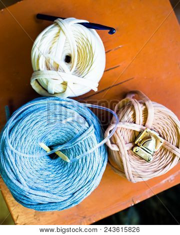 Three Reel Thread With Knitting Hook On The Brown Table