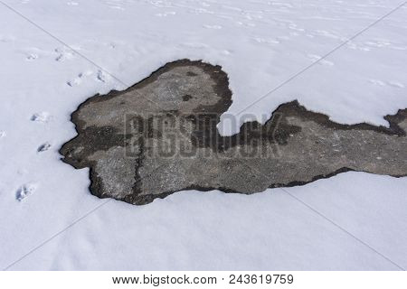 Snow On The Asphalt Melts Under The Rays Of The Spring Sun