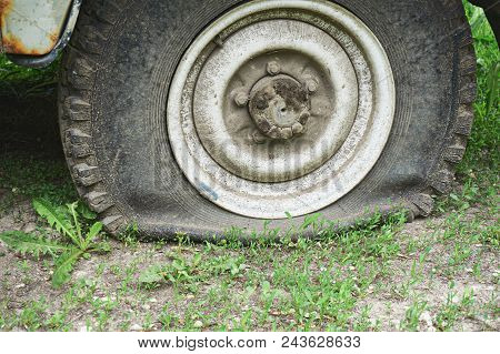 Flat Tire On An Old Rusty Suv Close-up. Abstract Background.