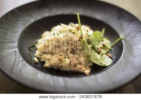 Close Up View At Risotto With Gem Fit And Levisticum Celery On A Wood Table Composition