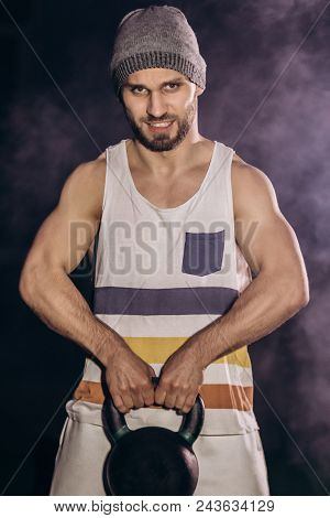 Handsome Man Doing Exercise With Dumbbells. Photo Of Muscular Man Isolated On Dark Background. Stren