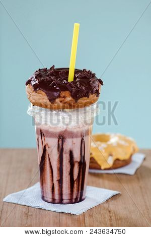 Chocolate And Donuts Extreme Milkshakein A Plastic Cup On Blue Background. Crazy Freakshake Or Overs