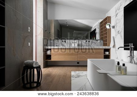 Bathroom In A Modern Style With Light Walls. There Is A Tiled Zone With A White Bath With Chrome Fau