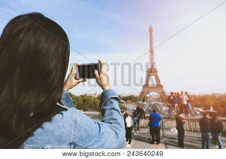 Woman Tourist Taking Photo By Phone Near The Eiffel Tower In Paris Under Sunlight And Blue Sky. Famo
