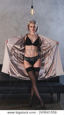 Sexy Young Woman In Lingerie And Underwear Taking Off Coat And Looking At Camera