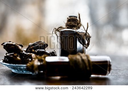 Sweet And Floral Essence Of Date Or Khajoor In Bottles On Wooden Surface Used I Flavored Chocolate A