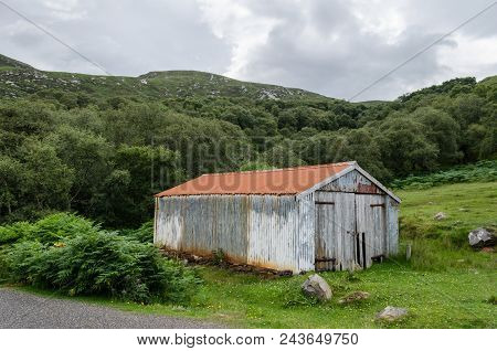 A Delapidated And Old Corrugated Garage Or Barn In A Rural Setting.