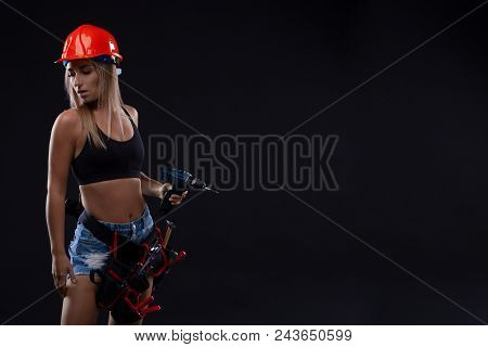 Beautiful Blond Woman With Heavy Perforator In Her Hands. Portrait Of A Female Construction Worker. 