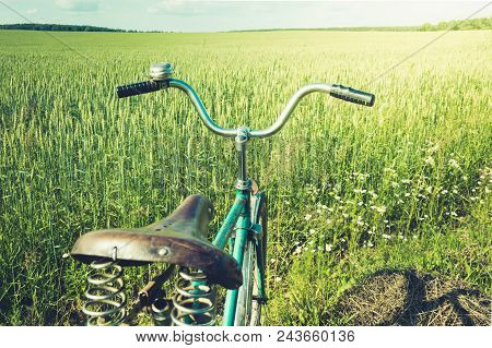 Vintage Handlebar With Bell On Bicycle. Summer Day For Trip. View Of Wheat Field. Outdoor. Closeup.
