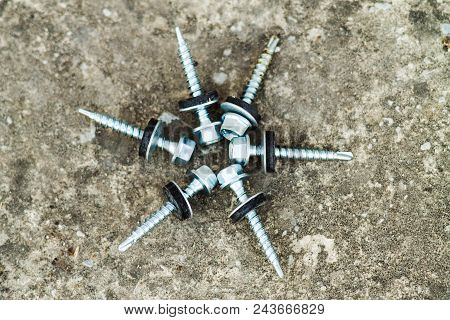 Zinc Plated Chipboard Screws With Countersunk Heads Stacked In A Circle Closeup On A Light Backgroun