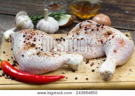 Raw Uncooked Chicken Legs With Spices On Wooden Board, Meat With Ingredients For Cooking. Close Up