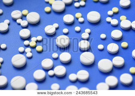 Yellow And White Tablets Scattered On A Blue Medical Table, Background