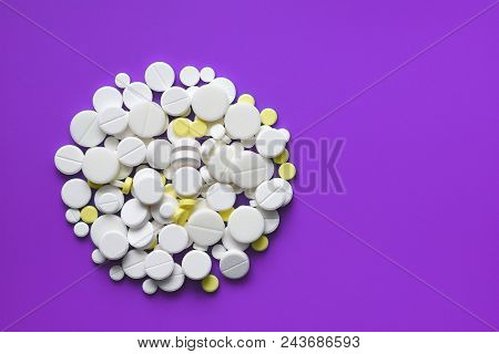 Yellow And White Tablets Scattered On A Violet Medical Table, Background, Copy Space