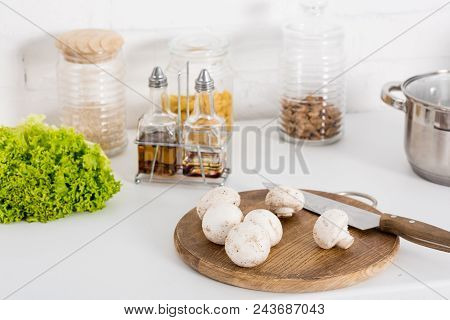 Ingredientes And Mushrooms On Wooden Board With Knife In Kitchen