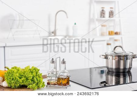 Fresh Ingredientes And Electric Stove With Saucepan On Kitchen