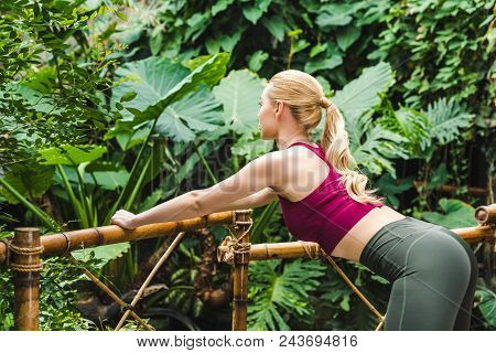 Athletic Young Sportswoman Warming Up Before Training In Park