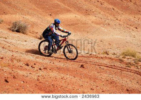 Biker sulle colline di terriccio rosso