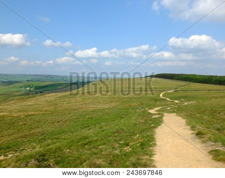 A Long Winding Footpath Running Into The Distance In Stoodley Moor In Yorkshire With Fields And Farm
