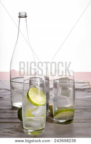 Stil Mineral Drink Water In Glass Bottle Served With Three Glasses With Ice Cubed, Lime And Lemon