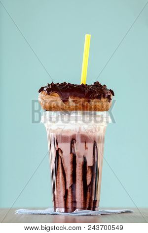 Chocolate And Donuts Extreme Milkshakein A Plastic Cup On Blue Background. Crazy Freakshake Or Overs