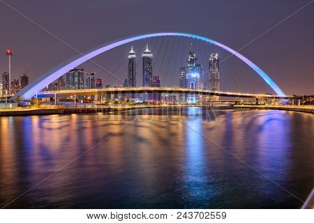 DUBAI, UAE - MAY 2018: Colorful sunset over Dubai Downtown skyscrapers and Tolerance bridge from the Dubai water canal. United Arab Emirates.