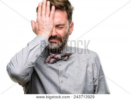 Middle age man, with beard and bow tie stressful keeping hand on head, tired and frustrated isolated over white background
