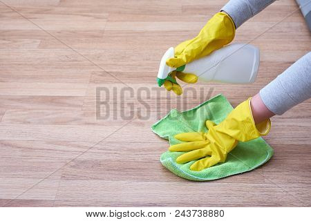 A Picture Of Hands In Yellow Gloves Cleaning The Floor.
