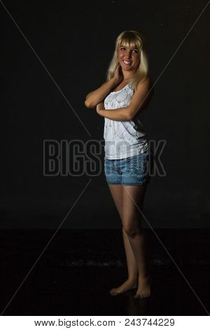 Nice Girl In The White Shirt And Water Drops Behind And Arround Her Illuminated By Light During A Ph