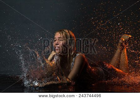 Nice Girl In The White Shirt And Water Drops Behind And Arround Her Illuminated By Light During A Ph