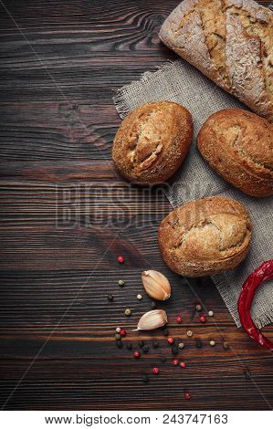 A Set Of Oil, Bread, Pepper, Garlic On A Brown Wooden Board