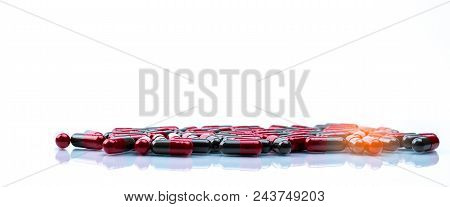 Pile Of Red And Grey Capsule Pills Isolated On White Background With Copy Space. Flunarizine : Drug 