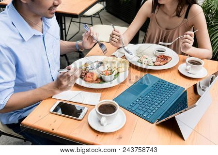 High angle view of the table of a young couple eating at restaurant with a tablet and a mobile phone on the table