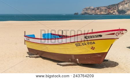 Colorful Traditional Old Wooden Fishing Boat On The Beach Of Fishing Village Of Nazare