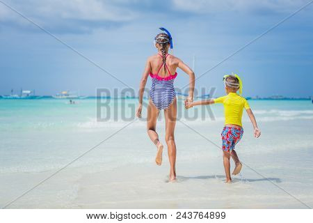 Brother And Sister Running And Having Fun On The Beach During The Hot Summer Vacation Day.