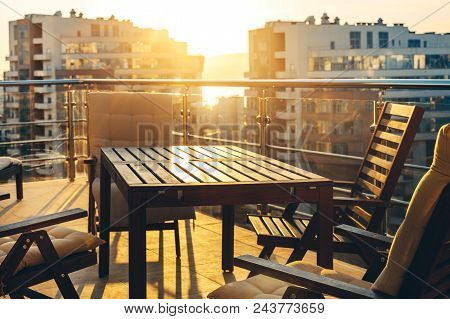 Outdoor Terrace With Garden Furniture In The Background Of The City And Sunset. Luxuary Apatraments Resort Recreation Summer Concept
