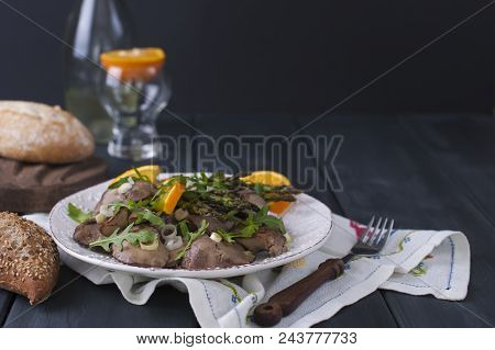 A Delicious Healthy Dinner, A Warm Chicken Liver Salad With Oranges And Rucola, On A Black Wooden Ba