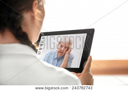 Diagnostic And Consultation With The Telemedicine, Doctor Holding A Tablet, Elderly Woman With Heada