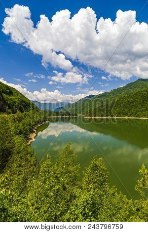 Landscape With Olt River In Romania Surrounded By Forest And Mountains