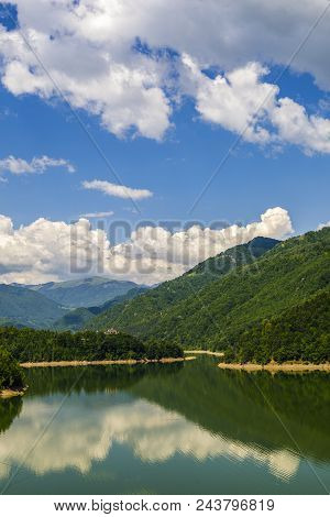 Landscape With Olt River In Romania Surrounded By Forest And Mountains